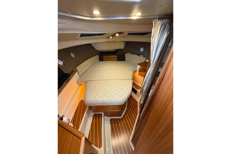 Slide: The Image of 2024 Ranger Tugs R-29 CB cabin interior with cozy bed and wooden flooring. - 7
