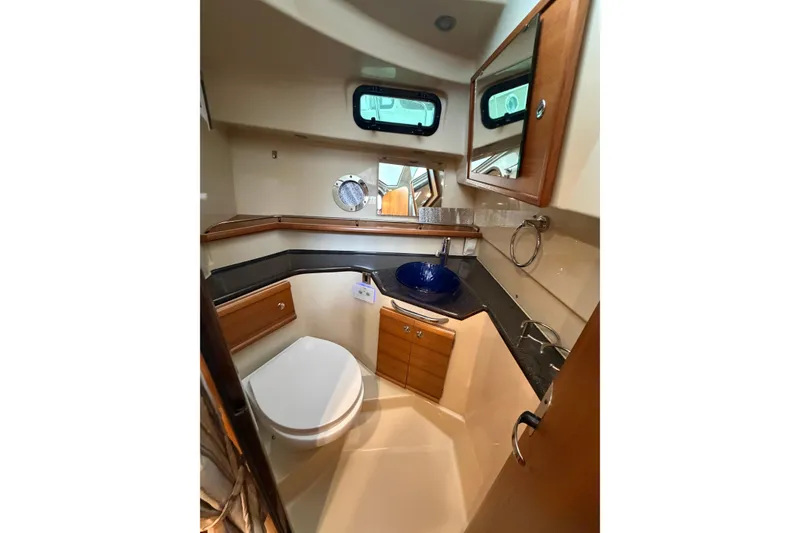 Slide: The Image of 2024 Ranger Tugs R-29 CB bathroom with modern fixtures and wood cabinetry. - 8