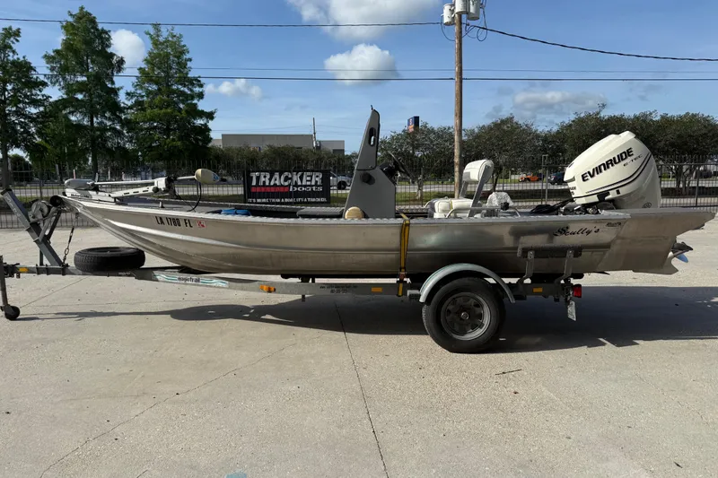 Slide: The Image of 2005 Scully 18 cc boat on trailer with Evinrude motor, parked outdoors. - 5