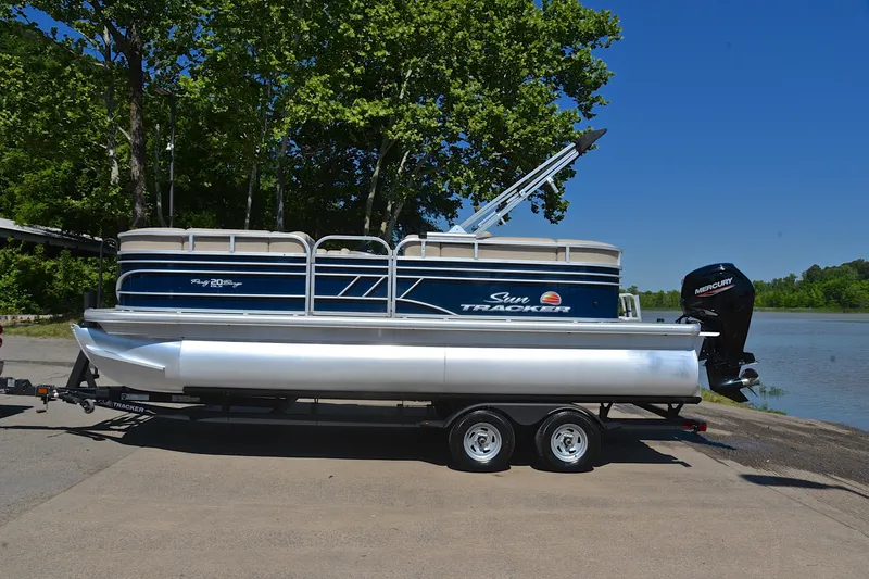 Slide: The Image of 2022 Sun Tracker Party Barge 20 DLX pontoon boat on trailer by a lake. - 11