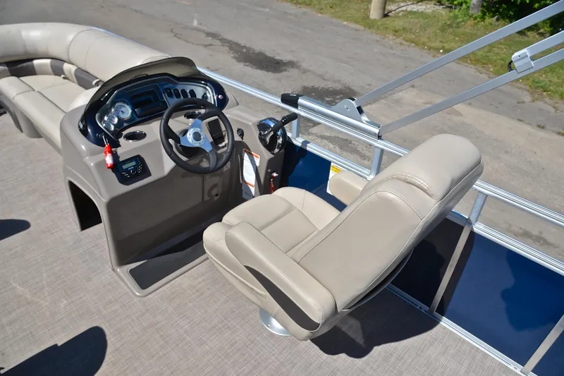 Slide: The Image of 2022 Sun Tracker Party Barge 20 DLX helm with beige seating and steering console. - 24