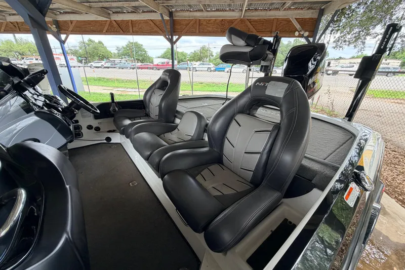 Slide: The Image of 2016 Nitro Z20 boat interior with black leather seats under a covered area. - 10