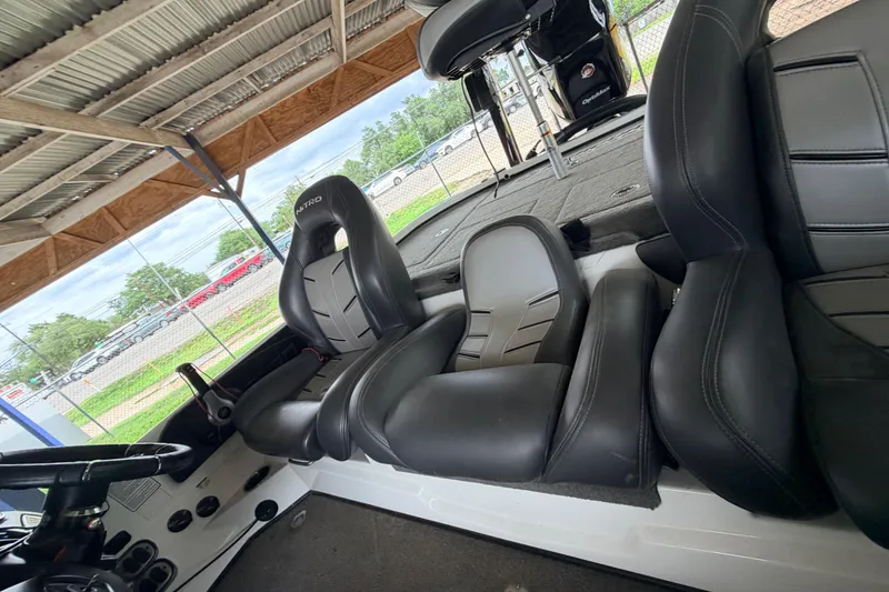 Slide: The Image of Interior of a 2016 Nitro Z20 boat with black leather seats under a metal roof. - 11