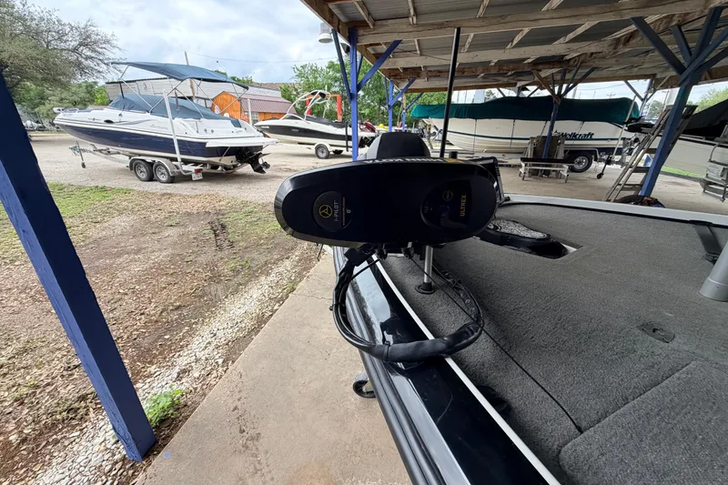 Slide: The Image of 2016 Nitro Z20 boat with trolling motor, parked under a shelter with other boats nearby. - 4