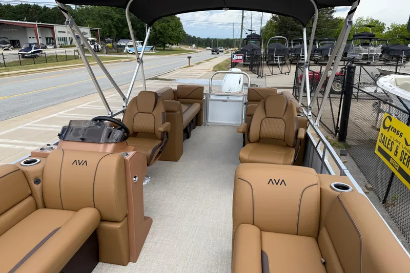 Slide: The Image of 2026 Avalon VENTURE QUAD LOUNGE pontoon boat with tan seating and canopy, parked outdoors. - 11