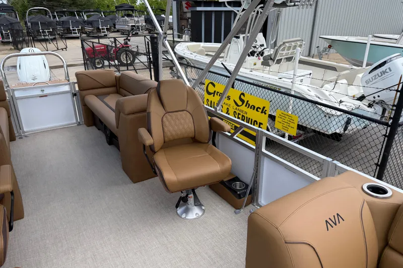 Slide: The Image of 2026 Avalon VENTURE QUAD LOUNGE interior with tan seating, docked near boats. - 13