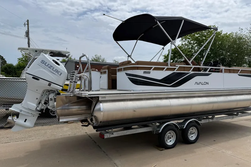 Slide: The Image of 2026 Avalon Venture Quad Lounge pontoon boat with Suzuki outboard motor on trailer. - 2
