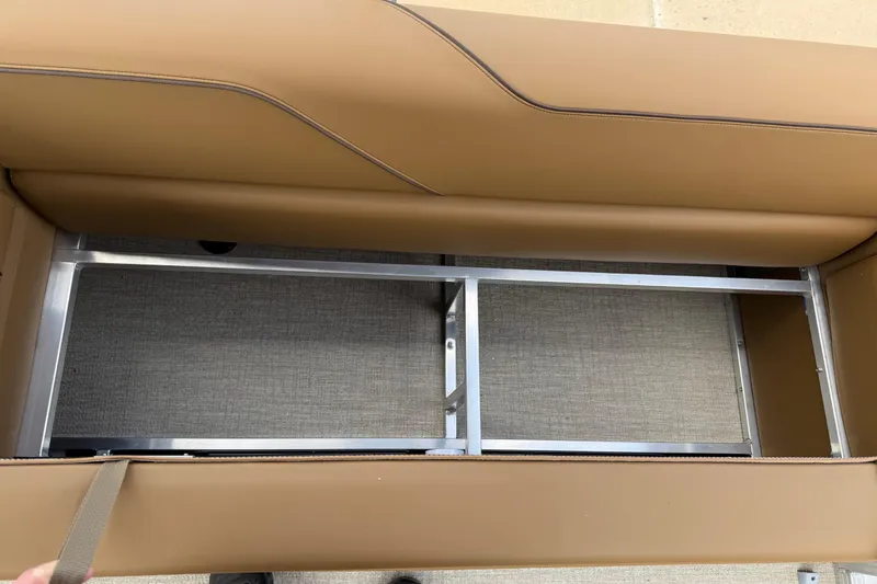 Slide: The Image of 2026 Avalon VENTURE QUAD LOUNGE seat storage compartment with metal frame and tan upholstery. - 33