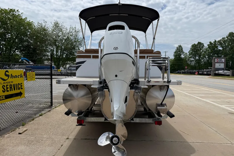 Slide: The Image of 2026 Avalon VENTURE QUAD LOUNGE pontoon boat with outboard motor, parked on pavement. - 4