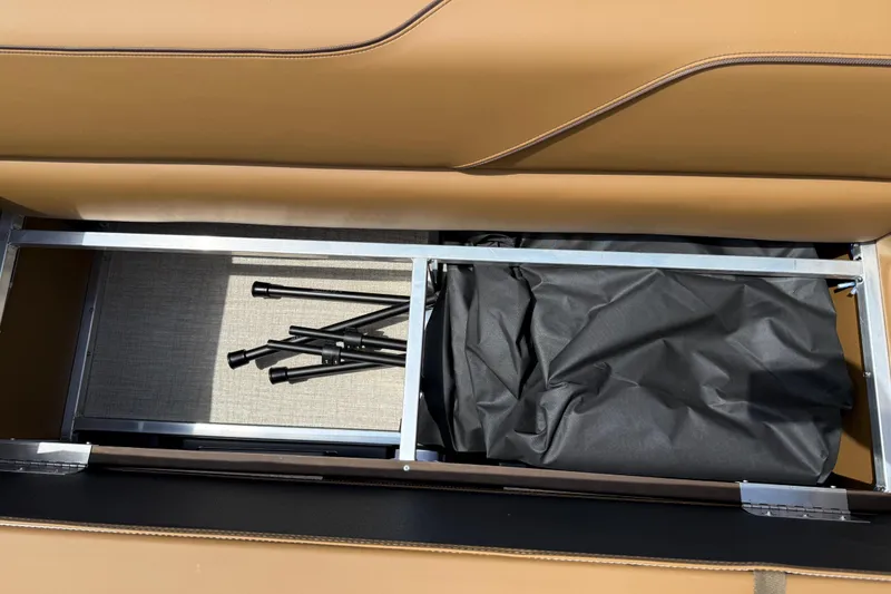 Slide: The Image of 2026 Avalon VENTURE QUAD LOUNGE storage compartment with black cover and metal frame. - 52