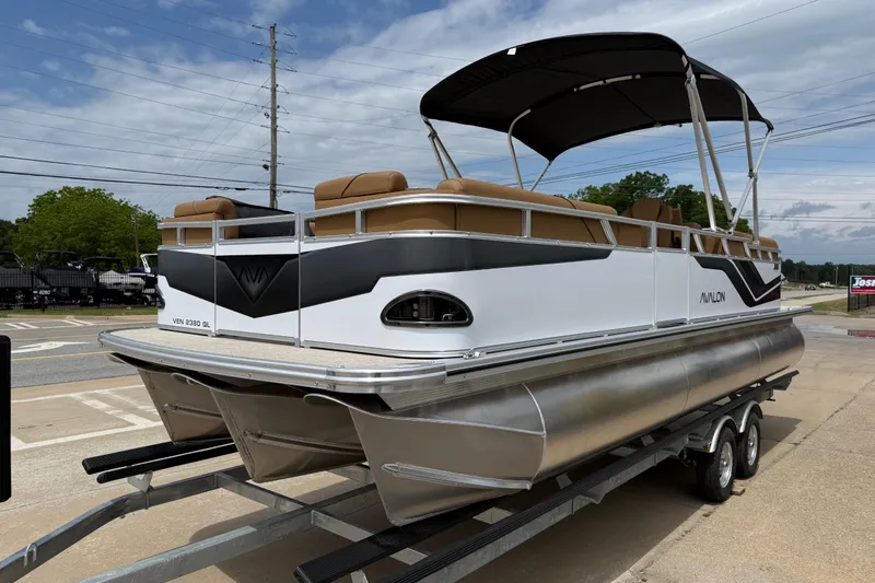 Slide: The Image of 2026 Avalon VENTURE QUAD LOUNGE pontoon boat on trailer, featuring sleek design and canopy. - 7