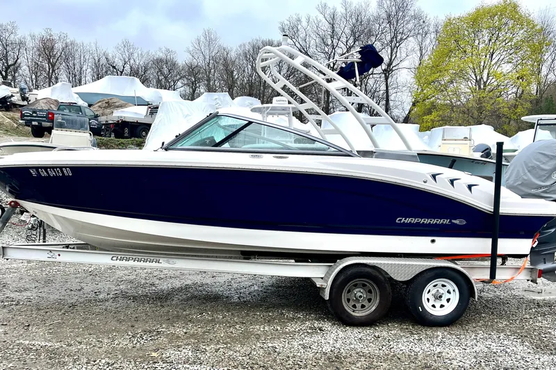 The Image of 2021 Chaparral 21 SSi OB boat on trailer, parked outdoors with trees in background. - 0