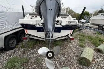Slide: The Image of 2021 Chaparral 21 SSi OB boat, rear view with outboard motor, parked on gravel. - 15