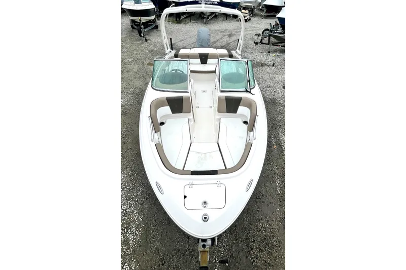 Slide: The Image of 2021 Chaparral 21 SSi OB boat with spacious seating, parked on gravel. - 8