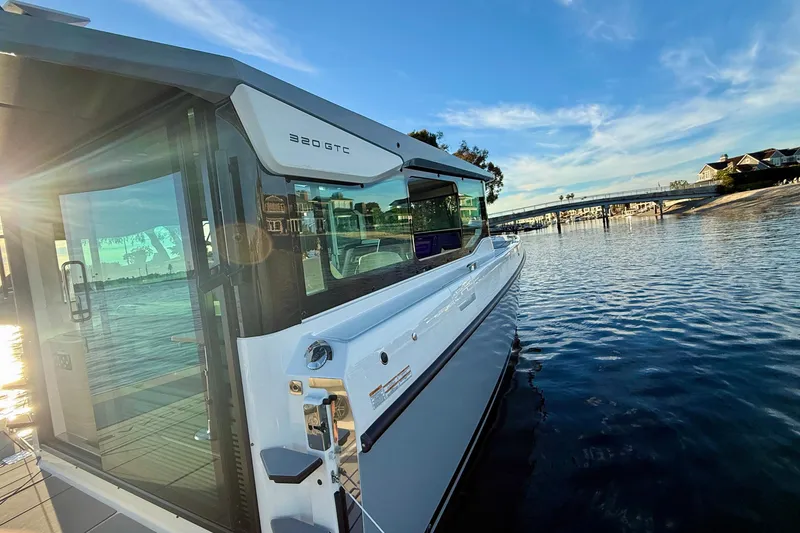 Slide: The Image of 2025 Saxdor 320 GTC boat on calm water with scenic background. - 16
