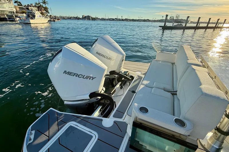 Slide: The Image of 2025 Saxdor 320 GTC boat with dual Mercury engines, docked at sunset. - 18