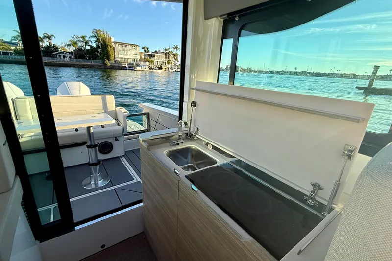 Slide: The Image of 2025 Saxdor 320 GTC boat interior with kitchenette and scenic water view. - 24