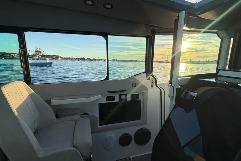 Slide: The Image of Interior view of 2025 Saxdor 320 GTC boat with scenic sunset over water. - 31