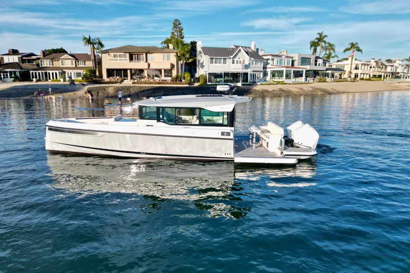 Slide: The Image of 2025 Saxdor 320 GTC boat cruising near luxury waterfront homes. - 4