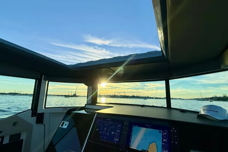 Slide: The Image of Interior view of 2025 Saxdor 320 GTC boat with sunset over water. - 40
