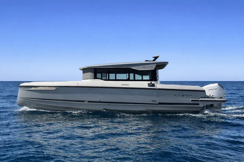 Slide: The Image of 2025 Saxdor 320 GTC boat cruising on open sea under clear blue sky. - 8