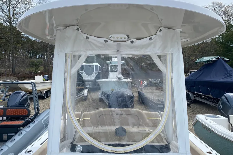 Slide: The Image of 2019 Sportsman Heritage 231 Center Console boat with protective canopy in a marina setting. - 11