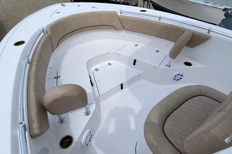 Slide: The Image of 2019 Sportsman Heritage 231 Center Console boat interior with beige seating and storage compartments. - 12