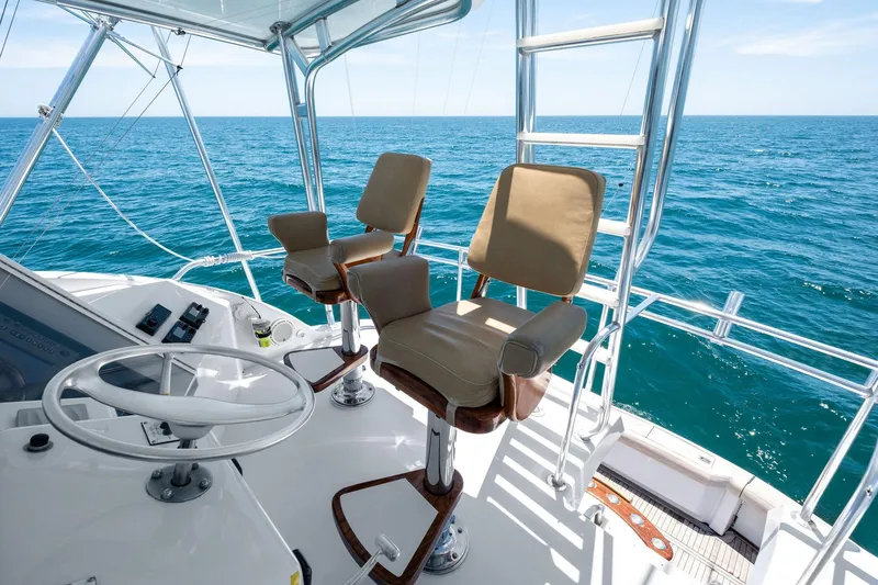 Slide: The Image of Flybridge of 1998 Hatteras 60 Convertible yacht with ocean view and helm chairs. - 12