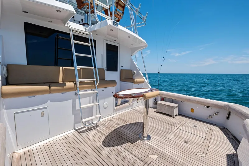 Slide: The Image of 1998 Hatteras 60 Convertible yacht deck with seating, ladder, and ocean view. - 21