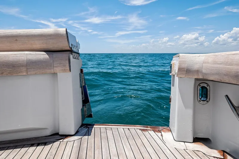 Slide: The Image of 1998 Hatteras 60 Convertible yacht deck overlooking the ocean under a clear blue sky. - 25