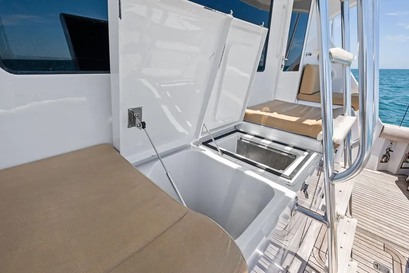Slide: The Image of 1998 Hatteras 60 Convertible yacht deck with seating and storage compartments. - 27