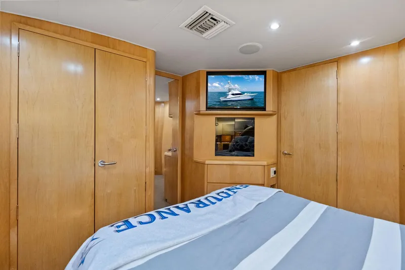 Slide: The Image of Interior of 1998 Hatteras 60 Convertible yacht bedroom with TV and wooden cabinetry. - 41