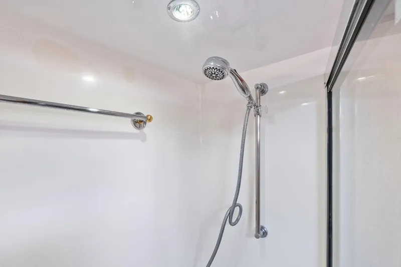 Slide: The Image of Shower area in 1998 Hatteras 60 Convertible yacht, featuring chrome fixtures and glass door. - 43