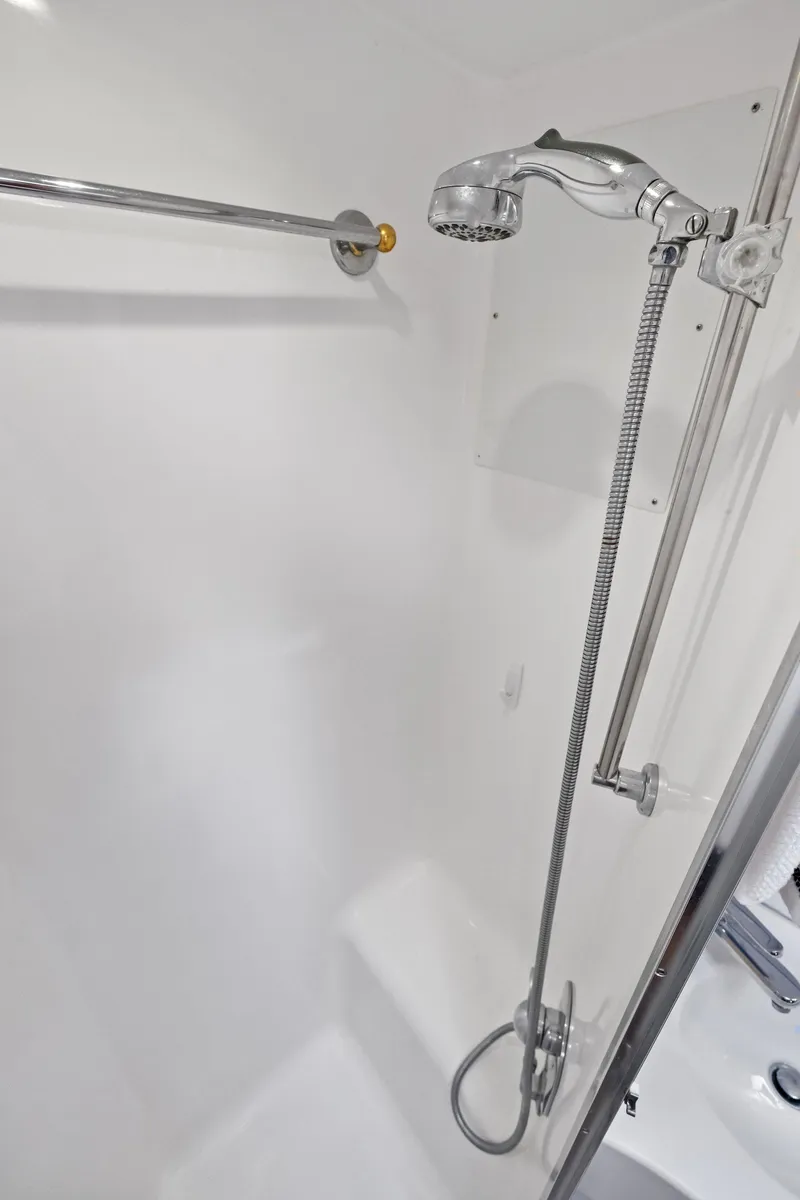 Slide: The Image of Shower area in 1998 Hatteras 60 Convertible yacht, featuring chrome fixtures and white interior. - 49