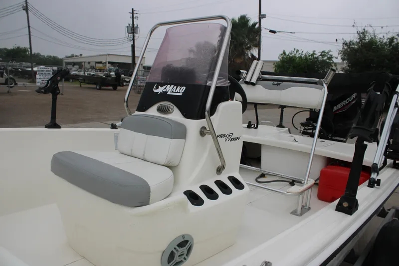 Slide: The Image of 2021 Mako Pro Skiff 17 CC boat with seating and steering console, parked outdoors. - 13