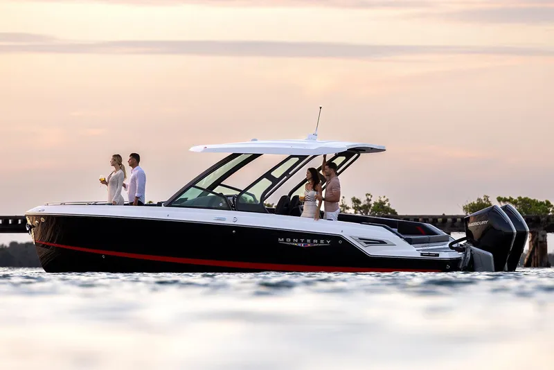 Slide: The Image of Manufacturer Provided Image: 2026 Monterey Elite 30 OB boat cruising at sunset with passengers enjoying the view. - 1