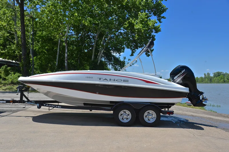 Slide: The Image of 2018 Tahoe 1950 boat on trailer by a lake, surrounded by trees. - 11