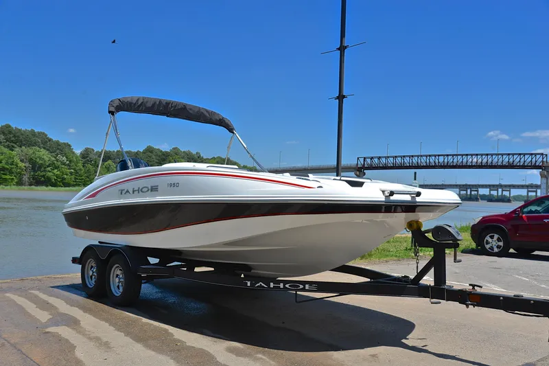 Slide: The Image of Tahoe 1950 boat on trailer by river, sunny day, bridge in background, 2018 model. - 16
