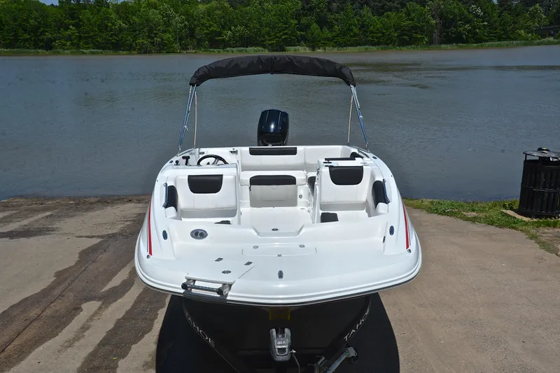 Slide: The Image of 2018 Tahoe 1950 boat at lakeside dock, featuring sleek white design and spacious seating. - 17