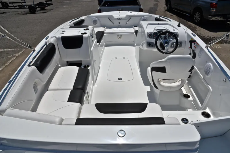 Slide: The Image of 2018 Tahoe 1950 boat interior with white and black seating, steering wheel, and spacious layout. - 18