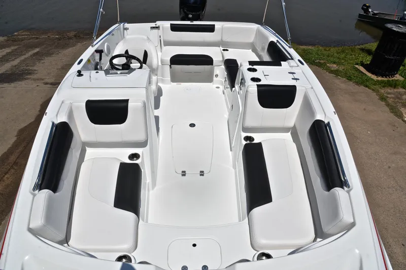 Slide: The Image of 2018 Tahoe 1950 boat interior with white and black seating, docked by the water. - 20