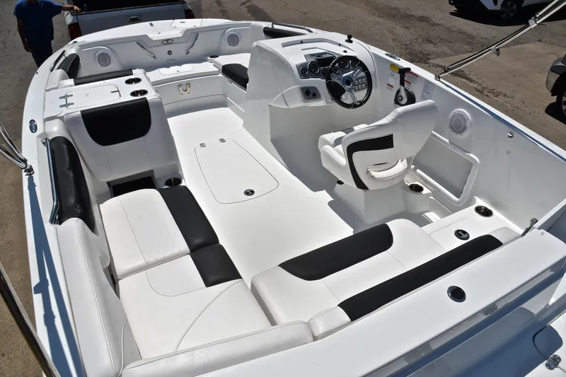 Slide: The Image of 2018 Tahoe 1950 boat interior with white and black seating, steering console, and cup holders. - 23