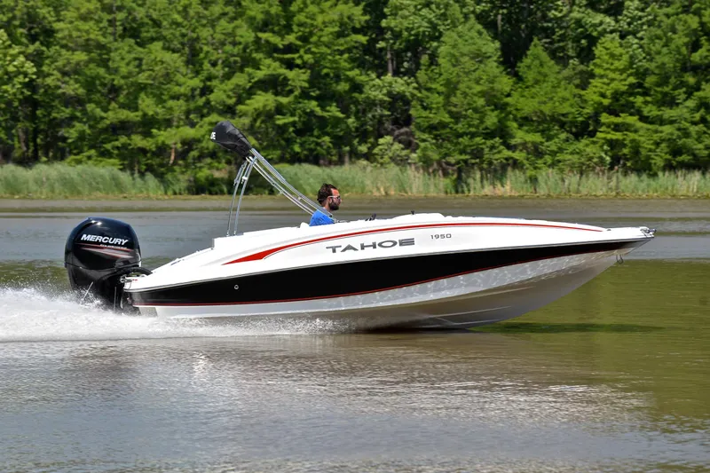 Slide: The Image of 2018 Tahoe 1950 boat cruising on a lake with lush green trees in the background. - 3