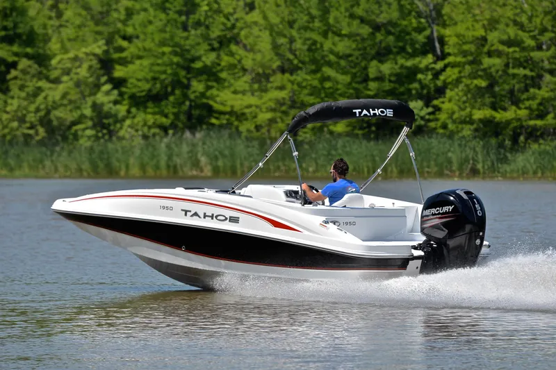 Slide: The Image of 2018 Tahoe 1950 boat cruising on a lake with lush green trees in the background. - 4