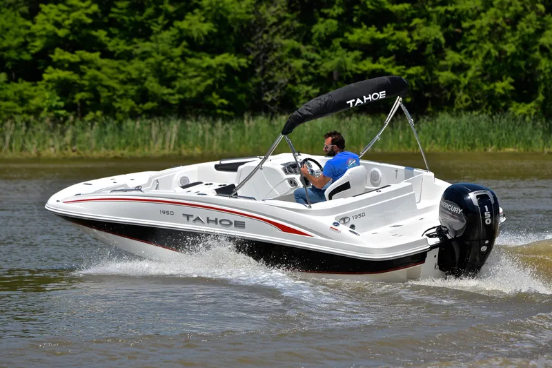 Slide: The Image of Man driving 2018 Tahoe 1950 boat on a lake with lush green background. - 6