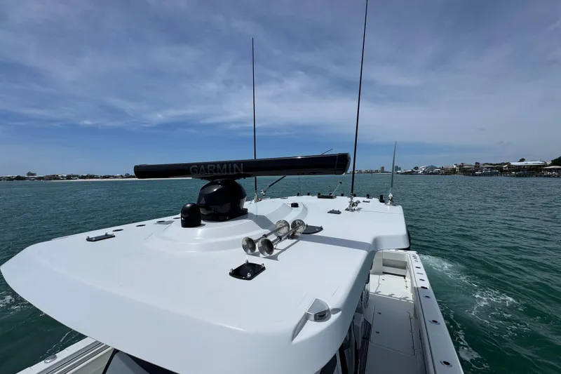 Slide: The Image of 2025 Invincible 40 Catamaran on water, featuring Garmin radar, clear skies, and coastal view. - 23