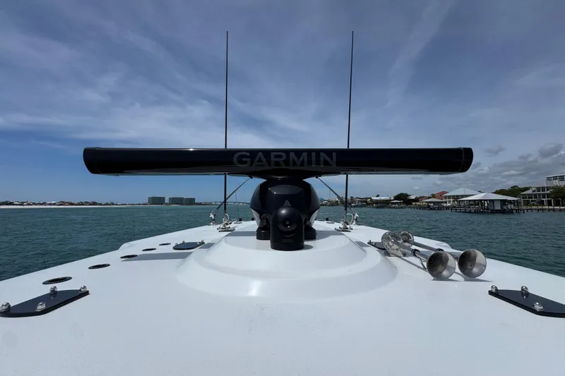 Slide: The Image of Invincible 40 Catamaran 2025 with Garmin radar on calm waters under blue sky. - 24