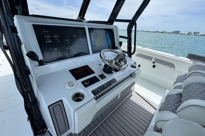 Slide: The Image of 2025 Invincible 40 Catamaran helm with dual displays and luxurious seating. - 32