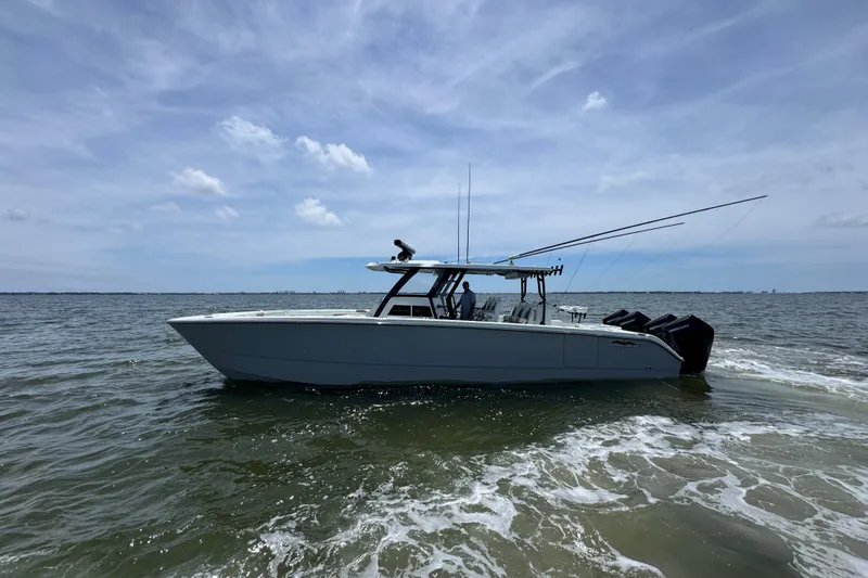 Slide: The Image of 2025 Invincible 40 Catamaran cruising on open water under a partly cloudy sky. - 8