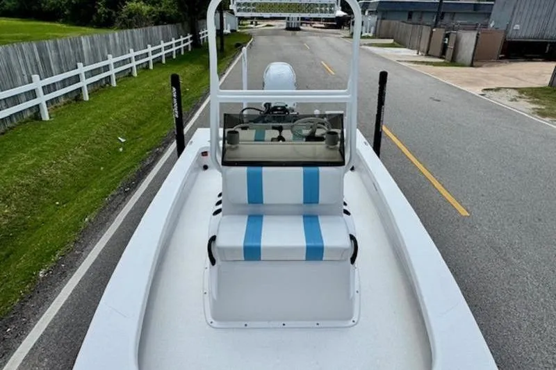 Slide: The Image of 2024 Majek 18 M2 boat on road, featuring blue-striped seating and steering console. - 13